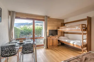 a bedroom with a bunk bed and a table and chairs at Studio Espérance - Welkeys in Megève
