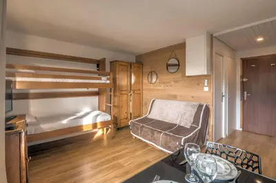 a bedroom with bunk beds and a table and a table at Studio Espérance - Welkeys in Megève