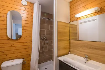 a bathroom with a sink and a toilet and a mirror at Studio Espérance - Welkeys in Megève