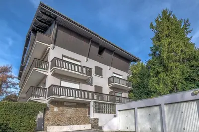 an apartment building with balconies and a fence at Studio Espérance - Welkeys in Megève