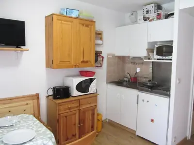 a small kitchen with white cabinets and a microwave at Résidence L'enclave - Enclave I599 MAE-9743 in Les Contamines-Montjoie
