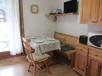 a kitchen with a table and chairs and a microwave at Résidence L'enclave - Enclave I599 MAE-9743 in Les Contamines-Montjoie