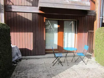 two chairs and a table in front of a building at Résidence L'enclave - Enclave I599 MAE-9743 in Les Contamines-Montjoie