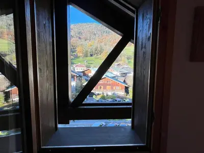 a window with a view of a town from a house at Confortable T3 au cœur de Samoëns avec WIFI et parking - FR-1-629-152 in Samoëns