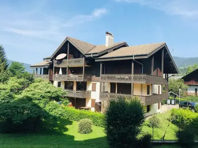 a large house on a hill with a green yard at Confortable T3 au cœur de Samoëns avec WIFI et parking - FR-1-629-152 in Samoëns