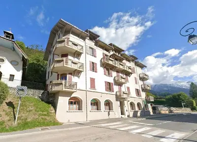 a large white building with balconies on a street at Refuge des Cols Verts Parking Cozy Relaxing in Saint-Gervais-les-Bains