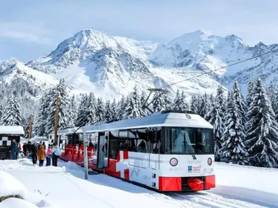 a red and white train on a snow covered mountain at Refuge des Cols Verts Parking Cozy Relaxing in Saint-Gervais-les-Bains