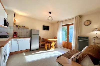 a kitchen with a refrigerator and a table in a room at Bright apartment in Combloux near ski in Combloux