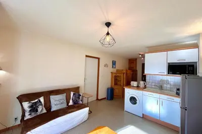a living room with a couch and a kitchen at Bright apartment in Combloux near ski in Combloux