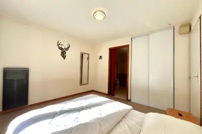 a bedroom with a bed with a antler on the wall at Bright apartment in Combloux near ski in Combloux