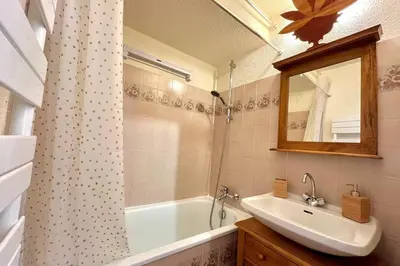 a bathroom with a sink and a tub and a mirror at Bright apartment in Combloux near ski in Combloux