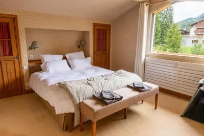 a bedroom with a bed and a large window at Spacious Apartment 4BR 10P Megève Center in Megève