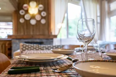 a table with plates and a wine glass on it at Spacious Apartment 4BR 10P Megève Center in Megève