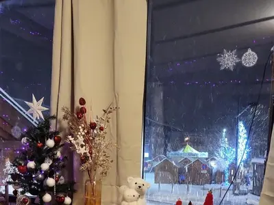 a christmas window with a christmas tree in a room at Duplex Centre Station 5 Pers, Animaux Adm - FR-1-836-37 in Arâches-la-Frasse
