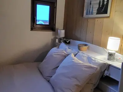 a bedroom with a bed with a table and a window at Duplex Centre Station 5 Pers, Animaux Adm - FR-1-836-37 in Arâches-la-Frasse