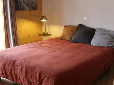 a bedroom with a large bed with a red blanket at Appartement standing 2 chambres, centre Arâches, 5 pers, parking, wifi - FR-1-836-8 in Arâches-la-Frasse