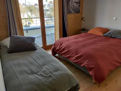 a bedroom with two beds and a large window at Appartement standing 2 chambres, centre Arâches, 5 pers, parking, wifi - FR-1-836-8 in Arâches-la-Frasse