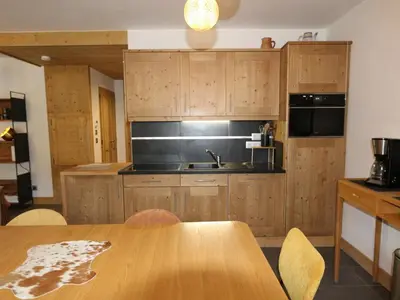 a kitchen with wooden cabinets and a wooden table at Appartement standing 2 chambres, centre Arâches, 5 pers, parking, wifi - FR-1-836-8 in Arâches-la-Frasse