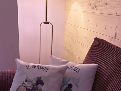 a lamp sitting next to a couch with a pillow at Appartement neuf 3 chambres avec jardin et parking à Arâches-la-Frasse - FR-1-836-48 in Arâches-la-Frasse