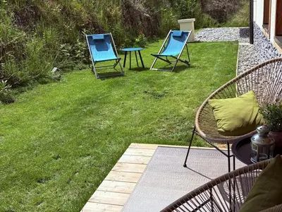 two blue chairs and a table on a lawn at Appartement neuf 3 chambres avec jardin et parking à Arâches-la-Frasse - FR-1-836-48 in Arâches-la-Frasse