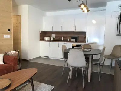 a kitchen and living room with a table and chairs at Appartement neuf 3 chambres avec jardin et parking à Arâches-la-Frasse - FR-1-836-48 in Arâches-la-Frasse