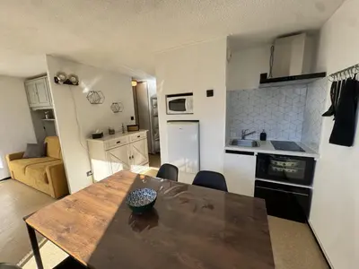 a kitchen and dining room with a wooden table at Studio 4 pers, cuisine équipée, parking privé, non-fumeur - FR-1-836-43 in Arâches-la-Frasse