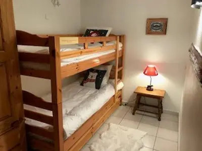 a room with two bunk beds and a lamp at Appartement Chalet 2 Chambres - 6 Pers, Wifi, Parking - FR-1-836-27 in Arâches-la-Frasse