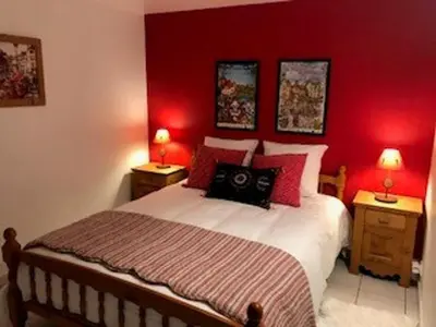 a bedroom with red walls and a bed with two night stands at Appartement Chalet 2 Chambres - 6 Pers, Wifi, Parking - FR-1-836-27 in Arâches-la-Frasse