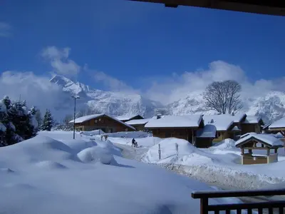 a snow covered village with a mountain in the background at Appartement Chalet 2 Chambres - 6 Pers, Wifi, Parking - FR-1-836-27 in Arâches-la-Frasse