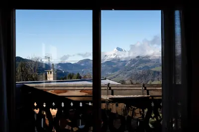 a wooden table with wine glasses and plates on it at Arbois Elégance - Ski aux pieds in Megève