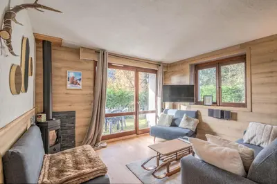 a living room with a couch and a fireplace at Appartement Perret - Welkeys in Megève