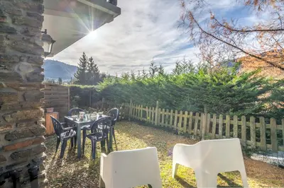 a patio with a table and chairs and a fence at Appartement Perret - Welkeys in Megève