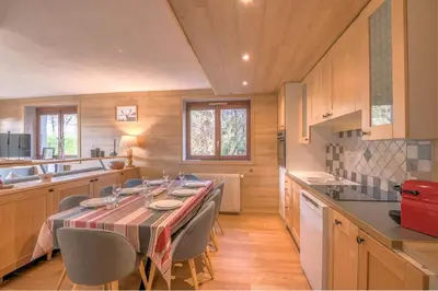 a dining room with a table and chairs in a kitchen at Appartement Perret - Welkeys in Megève