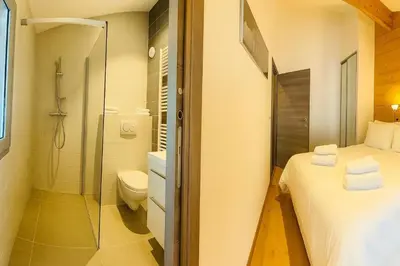 a bedroom with a white bed and a mirror at Stay in a modern apartment in Chamonix in Chamonix-Mont-Blanc