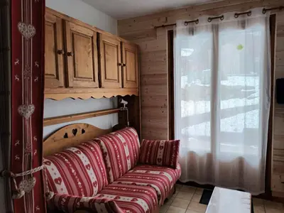 a living room with a couch and a window at Studio cosy avec terrasse, 4 pers, parking privatif - FR-1-836-35 in Arâches-la-Frasse