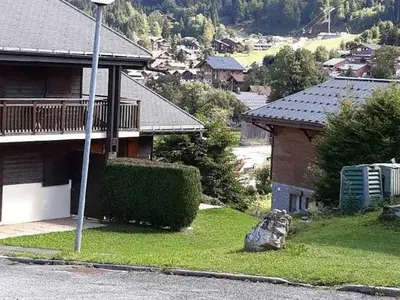 a house on the side of a street with a rock at Studio cosy avec terrasse, 4 pers, parking privatif - FR-1-836-35 in Arâches-la-Frasse