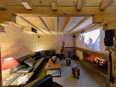 a living room with a couch and a large screen at Chalet cosy avec jacuzzi, billard, wifi et animaux admis pour 8 personnes - FR-1-836-32 in Arâches-la-Frasse