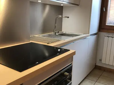 a kitchen with a sink and a black counter top at Appartement central 2 chambres, 6 personnes, Les Carroz d'Arâches - FR-1-836-25 in Arâches-la-Frasse