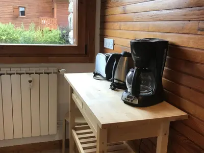 a coffeemaker sitting on a wooden table next to a window at Appartement central 2 chambres, 6 personnes, Les Carroz d'Arâches - FR-1-836-25 in Arâches-la-Frasse