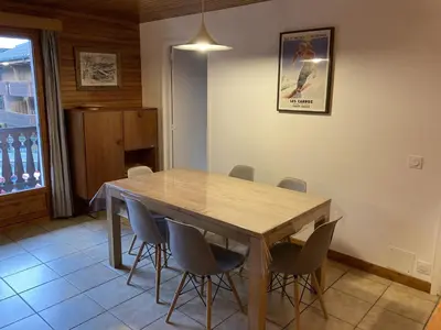 a dining room with a wooden table and chairs at Appartement central 2 chambres, 6 personnes, Les Carroz d'Arâches - FR-1-836-25 in Arâches-la-Frasse