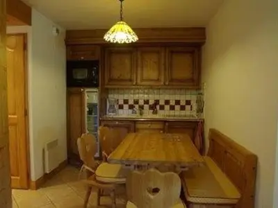 a kitchen with a wooden table with chairs and a dining room at Appartement 3 pièces, 7 pers, Animaux admis, Parking - FR-1-836-45 in Arâches-la-Frasse