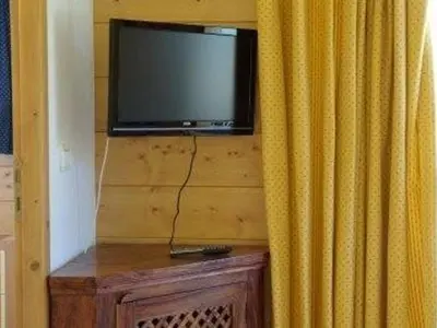 a flat screen tv on a wall with a curtain at Appartement 3 pièces, 7 pers, Animaux admis, Parking - FR-1-836-45 in Arâches-la-Frasse