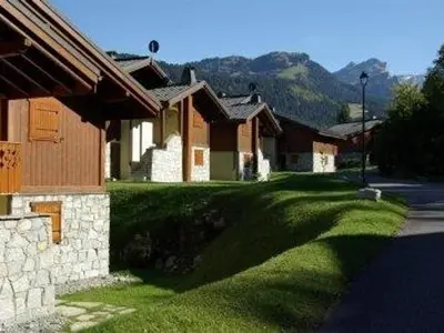 a house with a green lawn next to a street at Appartement 3 pièces, 7 pers, Animaux admis, Parking - FR-1-836-45 in Arâches-la-Frasse