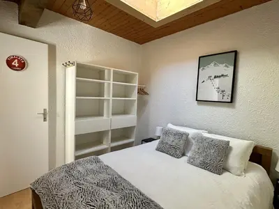 a bedroom with a bed with white sheets and pillows at Duplex 4 chambres, centre à 4min, skibus à la porte, WiFi - FR-1-836-53 in Arâches-la-Frasse