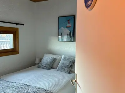 a bedroom with a bed and a window at Duplex 4 chambres, centre à 4min, skibus à la porte, WiFi - FR-1-836-53 in Arâches-la-Frasse
