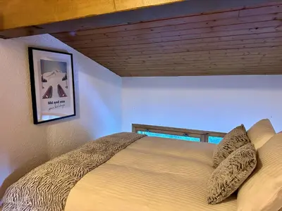 a bed in a bedroom with a wooden ceiling at Duplex 4 chambres, centre à 4min, skibus à la porte, WiFi - FR-1-836-53 in Arâches-la-Frasse