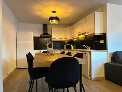 a kitchen with a table and chairs and a refrigerator at Duplex 4 chambres, centre à 4min, skibus à la porte, WiFi - FR-1-836-53 in Arâches-la-Frasse