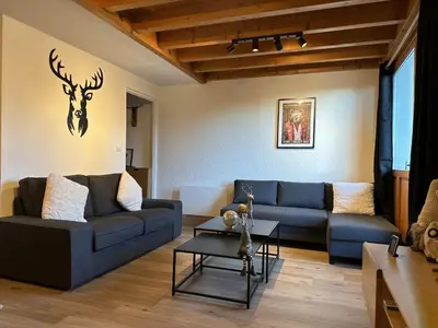 a living room with blue couches and a deer head on the wall at Duplex 4 chambres, centre à 4min, skibus à la porte, WiFi - FR-1-836-53 in Arâches-la-Frasse