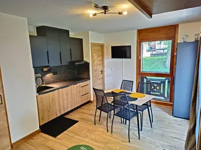 a kitchen with a table and chairs in a room at Appartement 2 pièces au pied de la télécabine avec animaux admis et parking - FR-1-836-30 in Arâches-la-Frasse