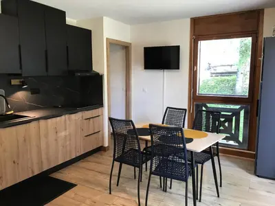 a kitchen with a table and chairs and a window at Appartement 2 pièces au pied de la télécabine avec animaux admis et parking - FR-1-836-30 in Arâches-la-Frasse